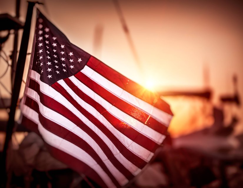 American flag waving at sunset
